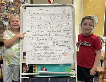 Two baker students in front of their Social Contract