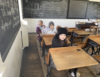3 students in an old schoolhouse