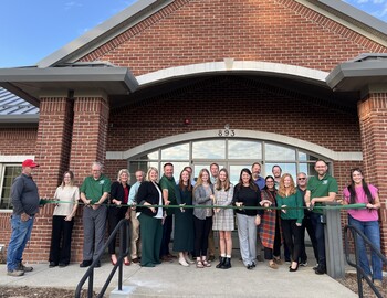 Administration Representatives, Board Members, Triangle Representatives, TowerPinkster Representatives cutting ribon in front of admin building.