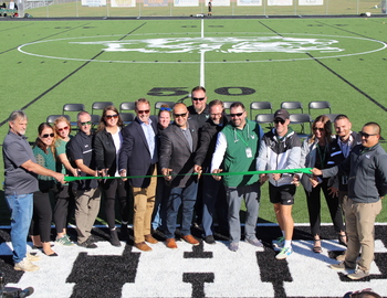 Team posing before cutting the ribbon