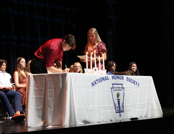 Student signing the book for NHS