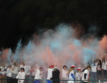 Red and blue powder being thrown in student section