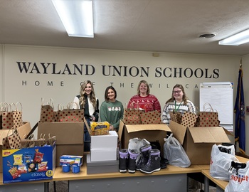 Representatives from Windemuller and Wayland Union Schools standing behind the donations.