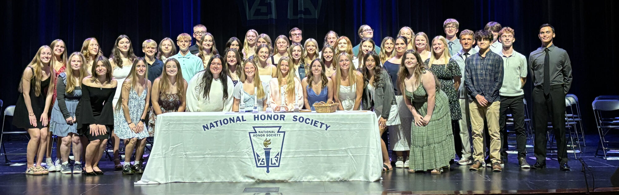 Group photo of NHS Inductees on stage behind NHS table