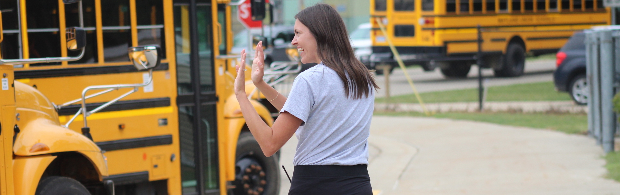 Baker Principal waving goodbye to busses