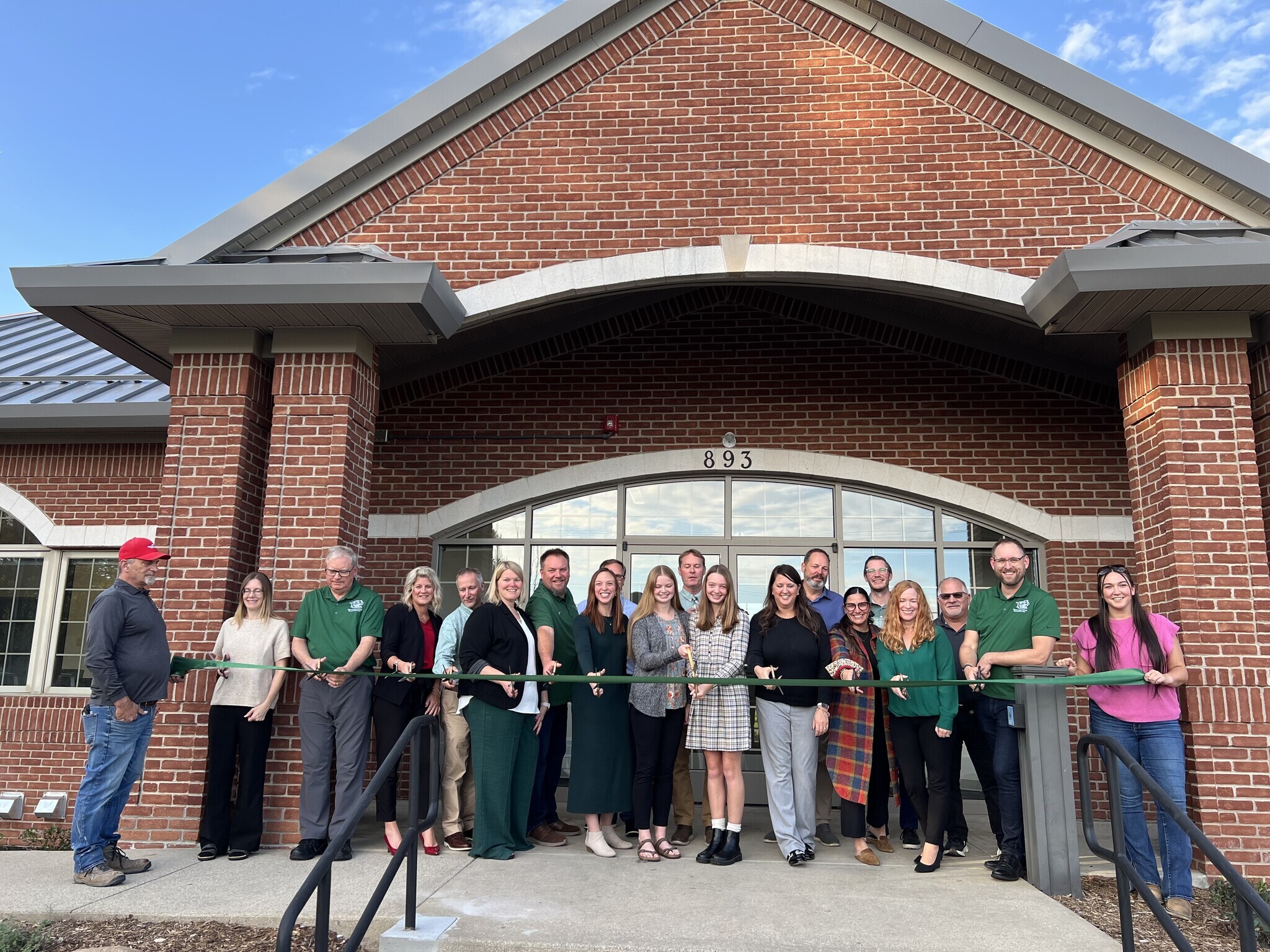 WUS, Triangle, and TowerPinkster representatives cutting ribbon in front of new admin building