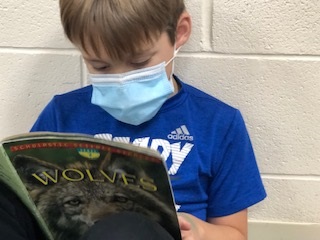 student with a mask reading