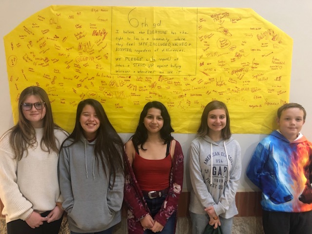 students standing in front of an anti-bullying Pledge Poster